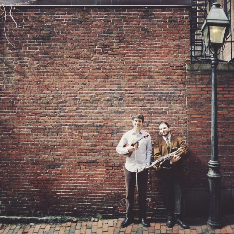 Nathan Gourley and Joey Abarta by a brick wall with instruments
